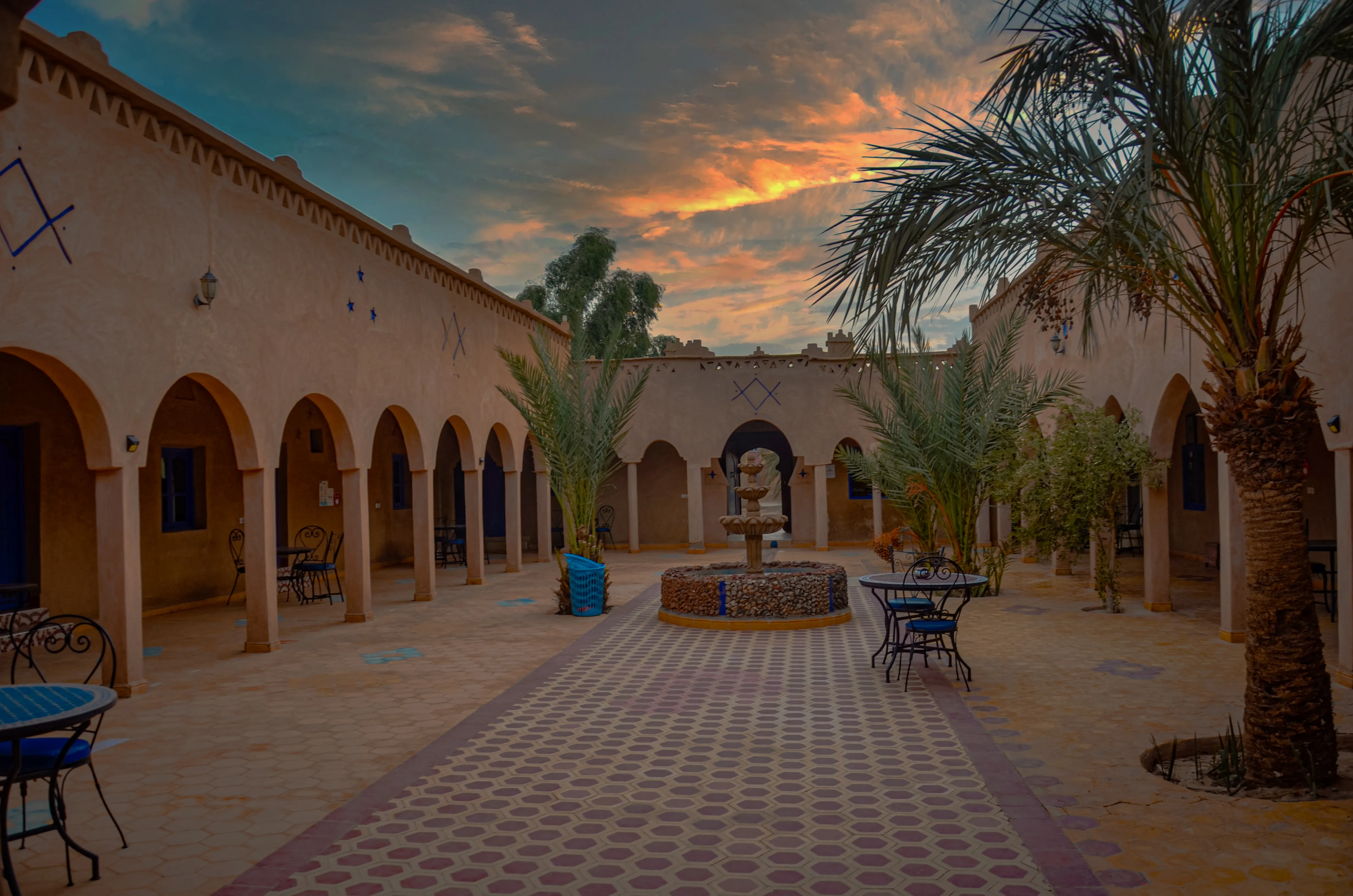 Habitación triple en el Hotel Les Roches Merzouga con piscina, ofreciendo una vista impresionante del desierto marroquí.